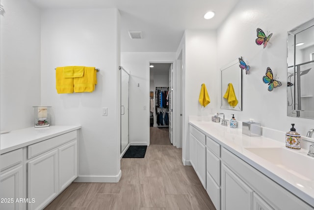 bathroom with vanity and a shower with door