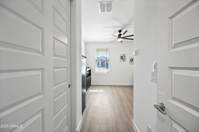 laundry room with electric dryer hookup, ceiling fan, and light hardwood / wood-style floors