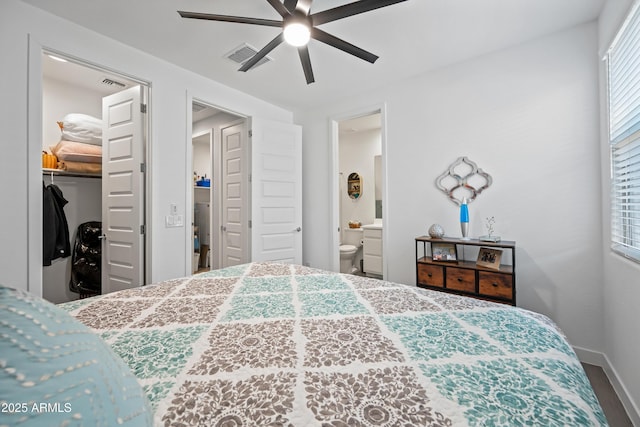 bedroom featuring connected bathroom, ceiling fan, a closet, and a walk in closet