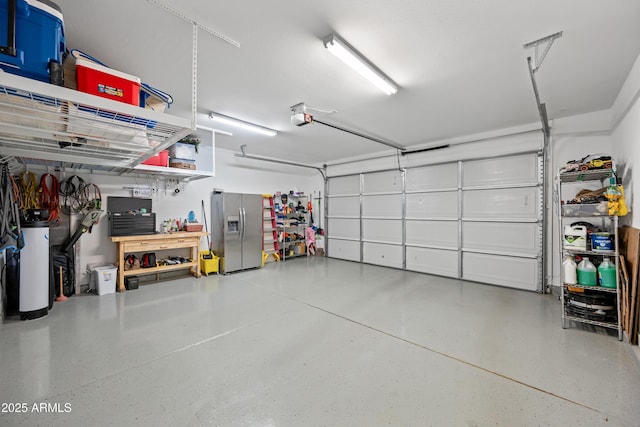 garage with stainless steel fridge, water heater, and a garage door opener