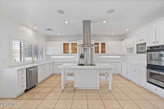 kitchen featuring appliances with stainless steel finishes, white cabinetry, a kitchen island, and a breakfast bar