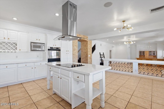 kitchen with white cabinets, stainless steel appliances, a center island, range hood, and a chandelier