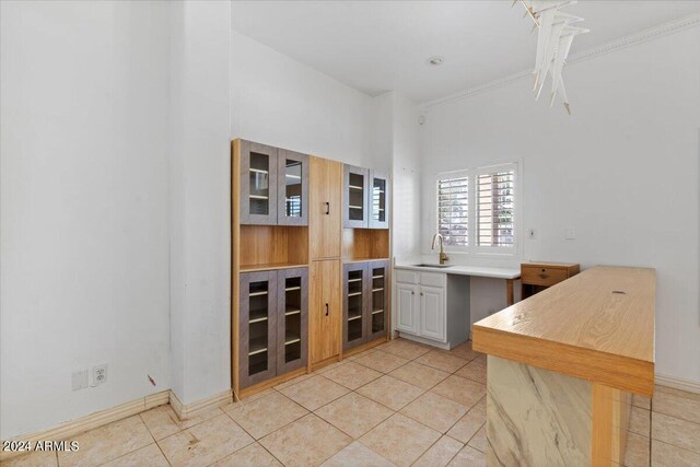 interior space with ornamental molding, light tile patterned flooring, and sink