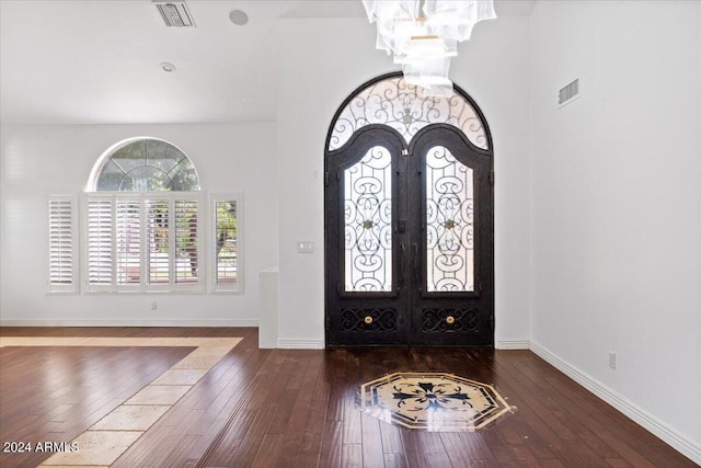 entrance foyer featuring a chandelier, dark hardwood / wood-style floors, and french doors