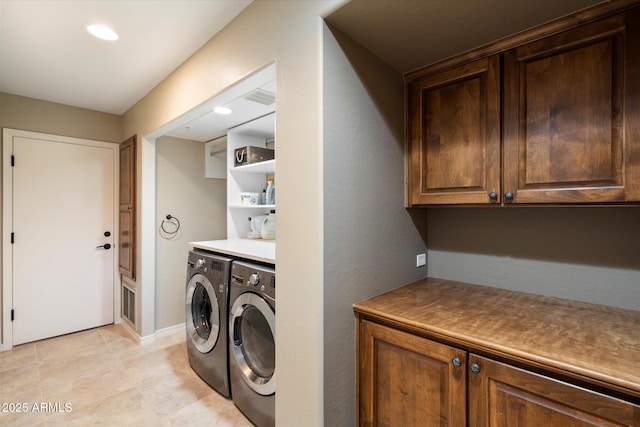 washroom with washing machine and clothes dryer and cabinets