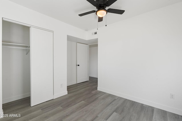 unfurnished bedroom featuring a closet, ceiling fan, and light hardwood / wood-style flooring