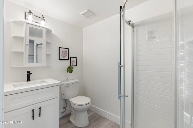 bathroom featuring hardwood / wood-style flooring, vanity, toilet, and a shower with shower door