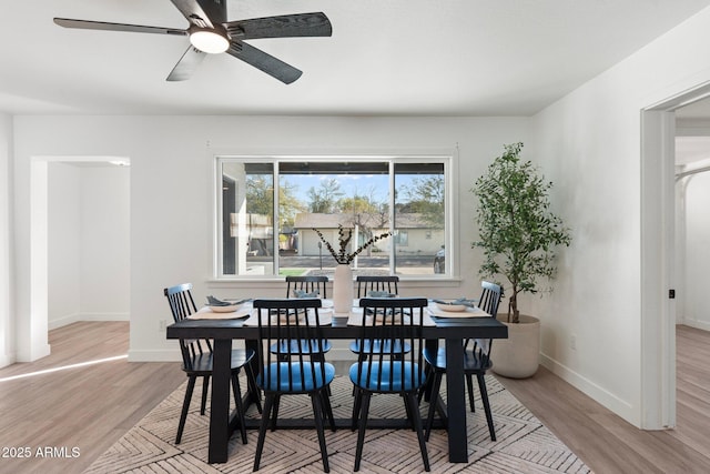 dining space with ceiling fan and light hardwood / wood-style floors