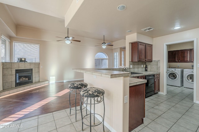 kitchen featuring light hardwood / wood-style floors, independent washer and dryer, a breakfast bar area, and a wealth of natural light