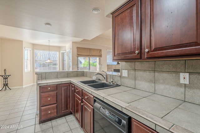 kitchen with backsplash, sink, pendant lighting, black dishwasher, and tile counters