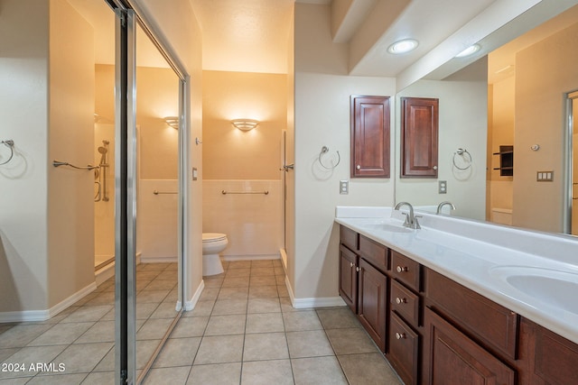 bathroom with toilet, a shower, vanity, and tile patterned floors