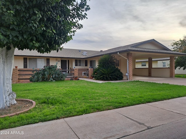 ranch-style home with a carport and a lawn