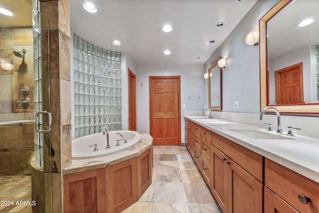 bathroom with vanity and shower with separate bathtub