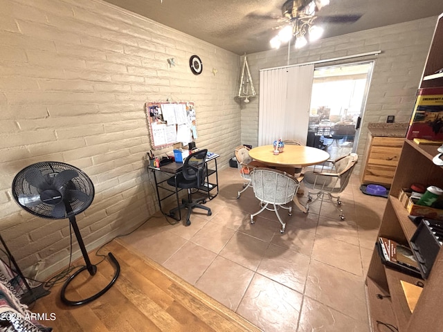 520 W Rocalla Ave, Ajo, AZ 85321 - dining area featuring brick wall, light tile patterned floors, a textured ceiling, and a ceiling fan