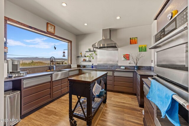 10975 E Janet Way, Dewey, AZ 86327 - kitchen featuring wall chimney range hood, dark countertops, a sink, double oven, and recessed lighting