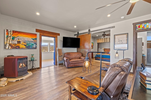 10975 E Janet Way, Dewey, AZ 86327 - living room with a wood stove, wood finished floors, ceiling fan, recessed lighting, and a barn door