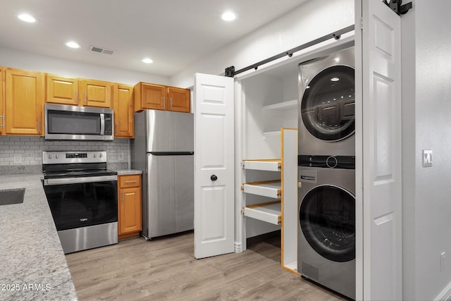 13636 N Hamilton Dr Unit 101, Fountain Hills, AZ 85268 - kitchen featuring visible vents, stacked washer and dryer, a barn door, light countertops, and appliances with stainless steel finishes