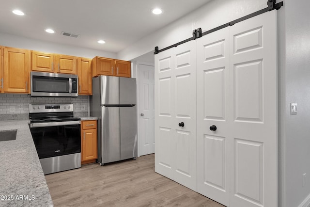 13636 N Hamilton Dr Unit 101, Fountain Hills, AZ 85268 - kitchen featuring visible vents, a barn door, light countertops, and stainless steel appliances