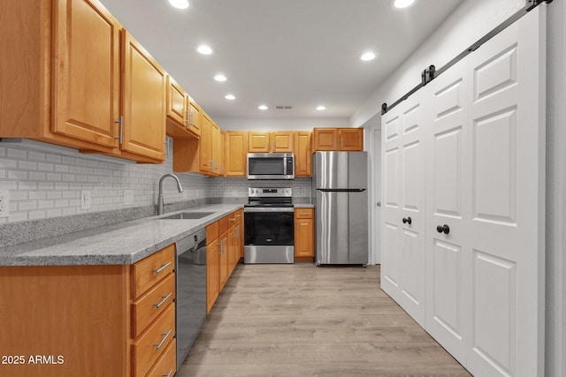 13636 N Hamilton Dr Unit 101, Fountain Hills, AZ 85268 - kitchen featuring light stone countertops, appliances with stainless steel finishes, a barn door, a sink, and recessed lighting