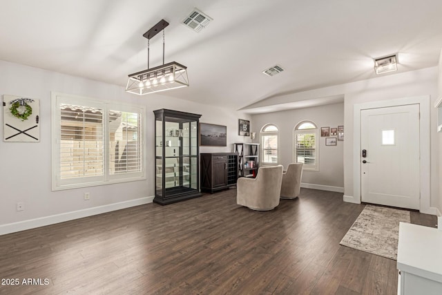 entrance foyer featuring dark wood finished floors, vaulted ceiling, visible vents, and baseboards