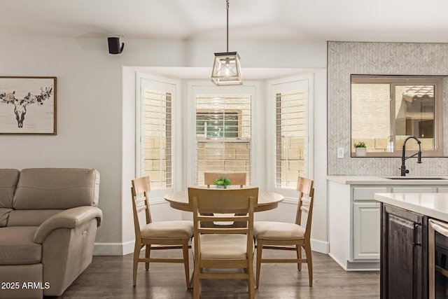 dining space featuring baseboards, beverage cooler, and dark wood-type flooring
