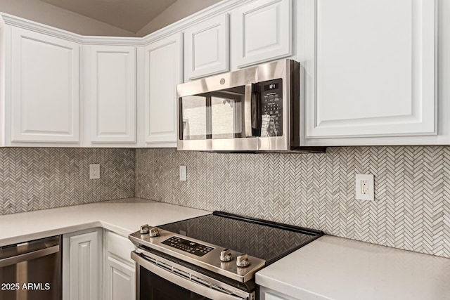 kitchen with backsplash, stainless steel appliances, white cabinets, and light countertops