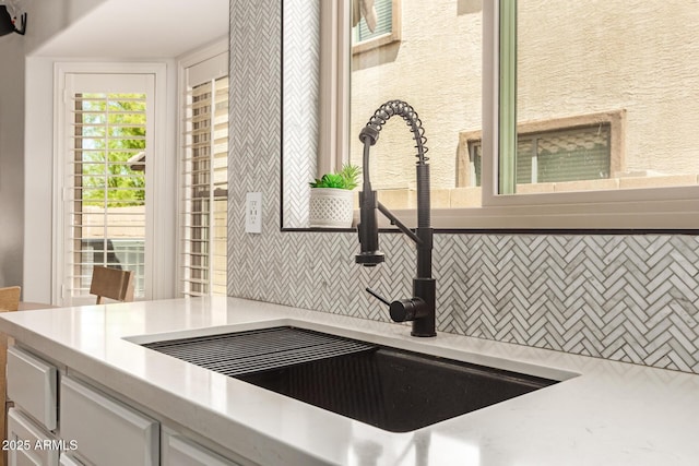 details featuring tasteful backsplash, a sink, and light countertops