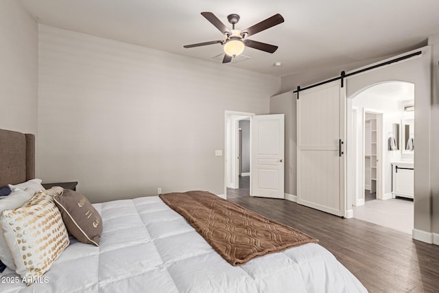 bedroom featuring baseboards, a ceiling fan, wood finished floors, and arched walkways