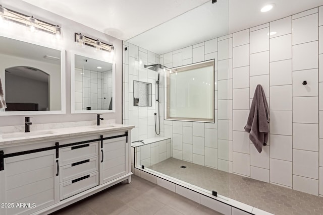 bathroom with tile patterned floors, a sink, double vanity, recessed lighting, and a walk in shower