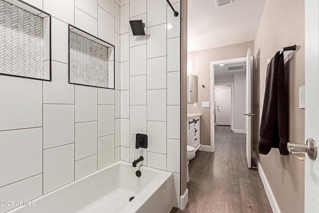 bathroom featuring  shower combination, toilet, baseboards, wood finished floors, and vanity