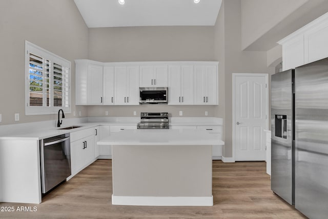 3376 E Lafayette Ave, Gilbert, AZ 85298 - kitchen featuring appliances with stainless steel finishes, white cabinetry, a kitchen island, light countertops, and a high ceiling