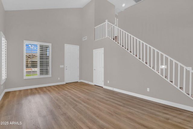 3376 E Lafayette Ave, Gilbert, AZ 85298 - unfurnished living room featuring wood finished floors, stairway, and a high ceiling