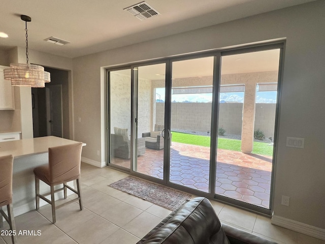 interior space featuring multiple windows, light tile patterned floors, and access to exterior