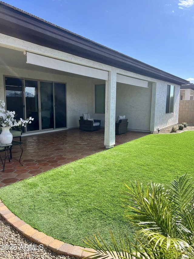 back of property featuring an outdoor hangout area, a patio area, and a lawn