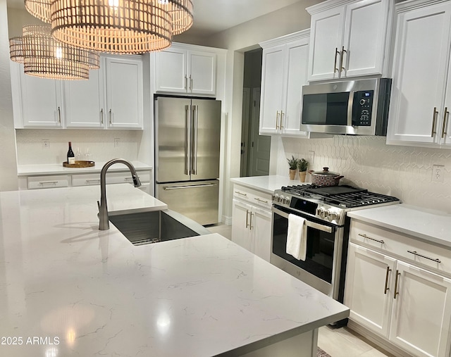 kitchen with sink, appliances with stainless steel finishes, backsplash, light stone counters, and white cabinets