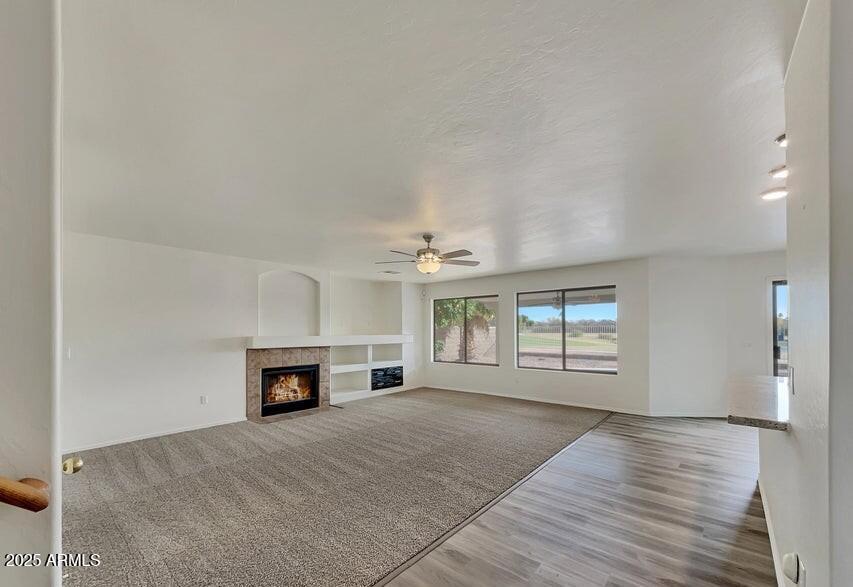 1345 E Betsy Ln, Gilbert, AZ 85296 - unfurnished living room with a tile fireplace, a ceiling fan, and wood finished floors