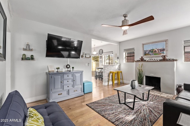 living room featuring ceiling fan and light hardwood / wood-style flooring