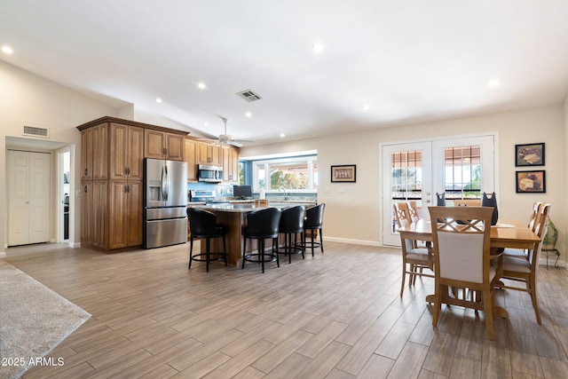 dining area with ceiling fan, lofted ceiling, and french doors