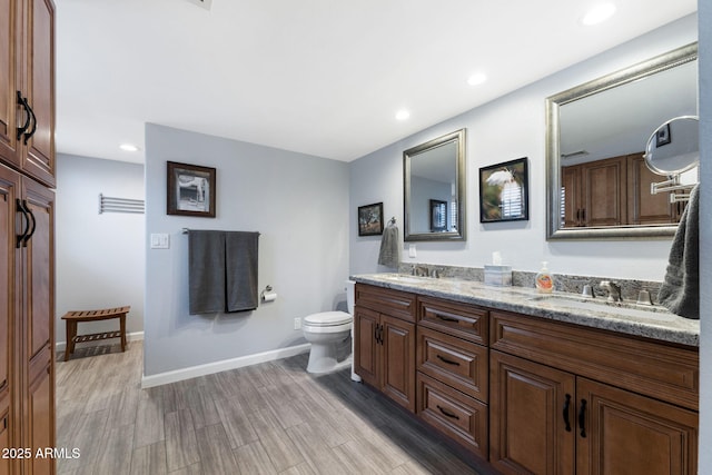 bathroom with toilet, vanity, and hardwood / wood-style floors