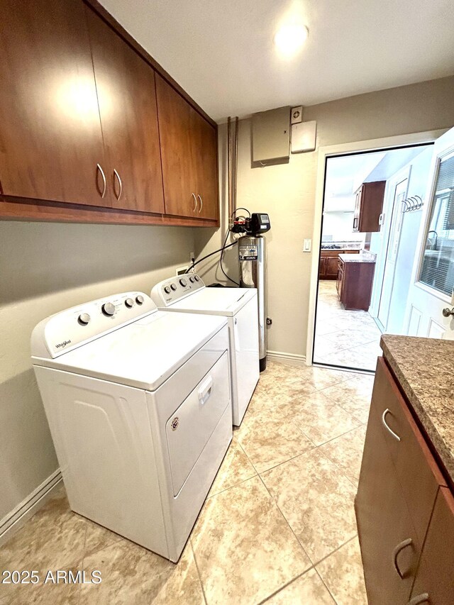 clothes washing area with cabinet space, light tile patterned floors, baseboards, and separate washer and dryer