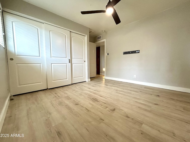unfurnished bedroom with a ceiling fan, a closet, light wood finished floors, baseboards, and visible vents
