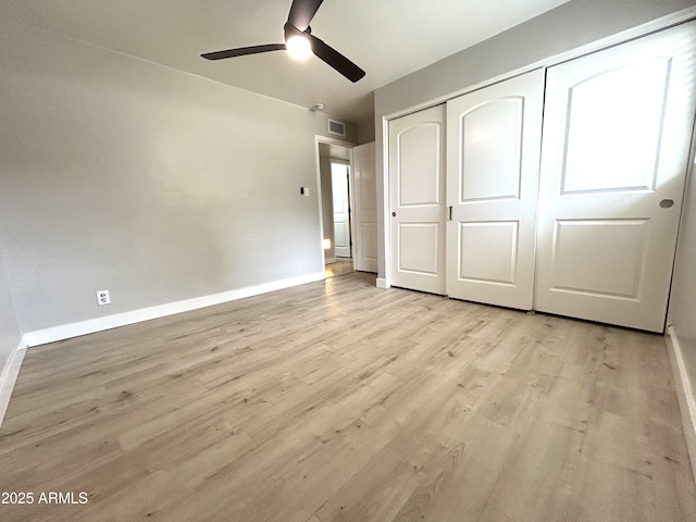unfurnished bedroom featuring baseboards, a closet, visible vents, and light wood-type flooring