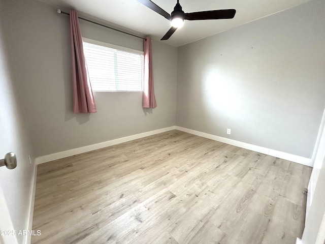 spare room with baseboards, a ceiling fan, and wood finished floors