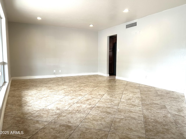 tiled spare room with baseboards, visible vents, and recessed lighting