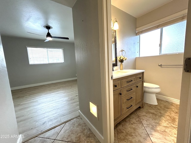 bathroom featuring a ceiling fan, tile patterned floors, vanity, baseboards, and toilet