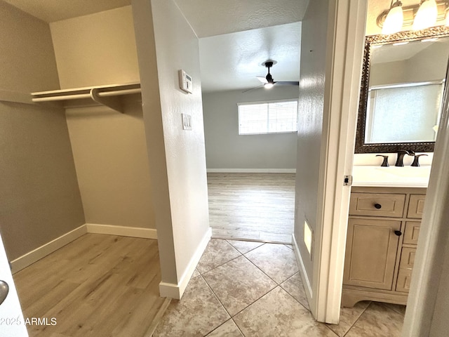 interior space featuring light wood-style flooring, baseboards, and a sink