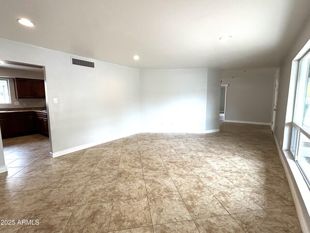 unfurnished room with baseboards, visible vents, and recessed lighting