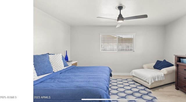 bedroom featuring ceiling fan, baseboards, and wood finished floors