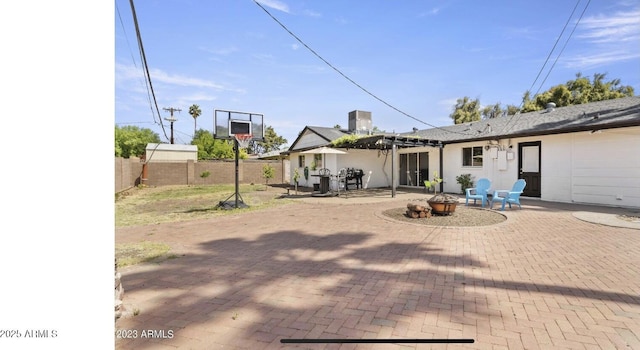 view of patio with a fenced backyard, a pergola, and an outdoor fire pit