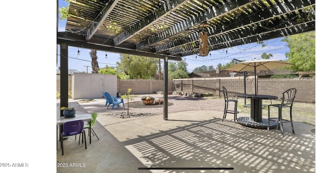 view of patio featuring a storage unit, a fenced backyard, a pergola, an outdoor structure, and outdoor dining space